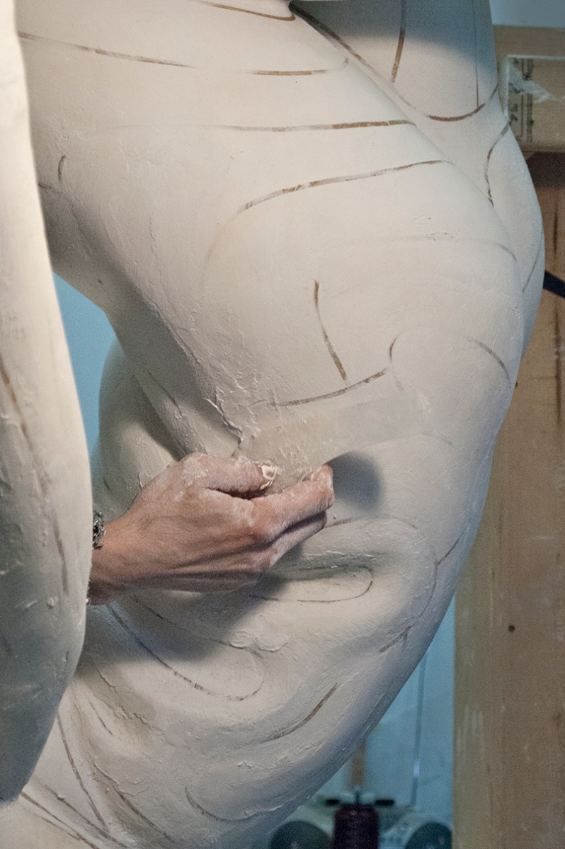 Refining plaster torso.