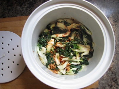 Sauce mixed into bok choy in kimchi preparation.